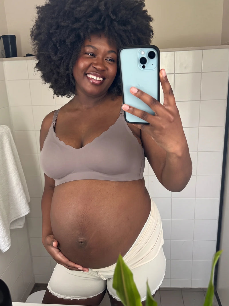 Pregnant mom smiling in a mirror selfie in the Aura Comfort Bra in Grey Purple