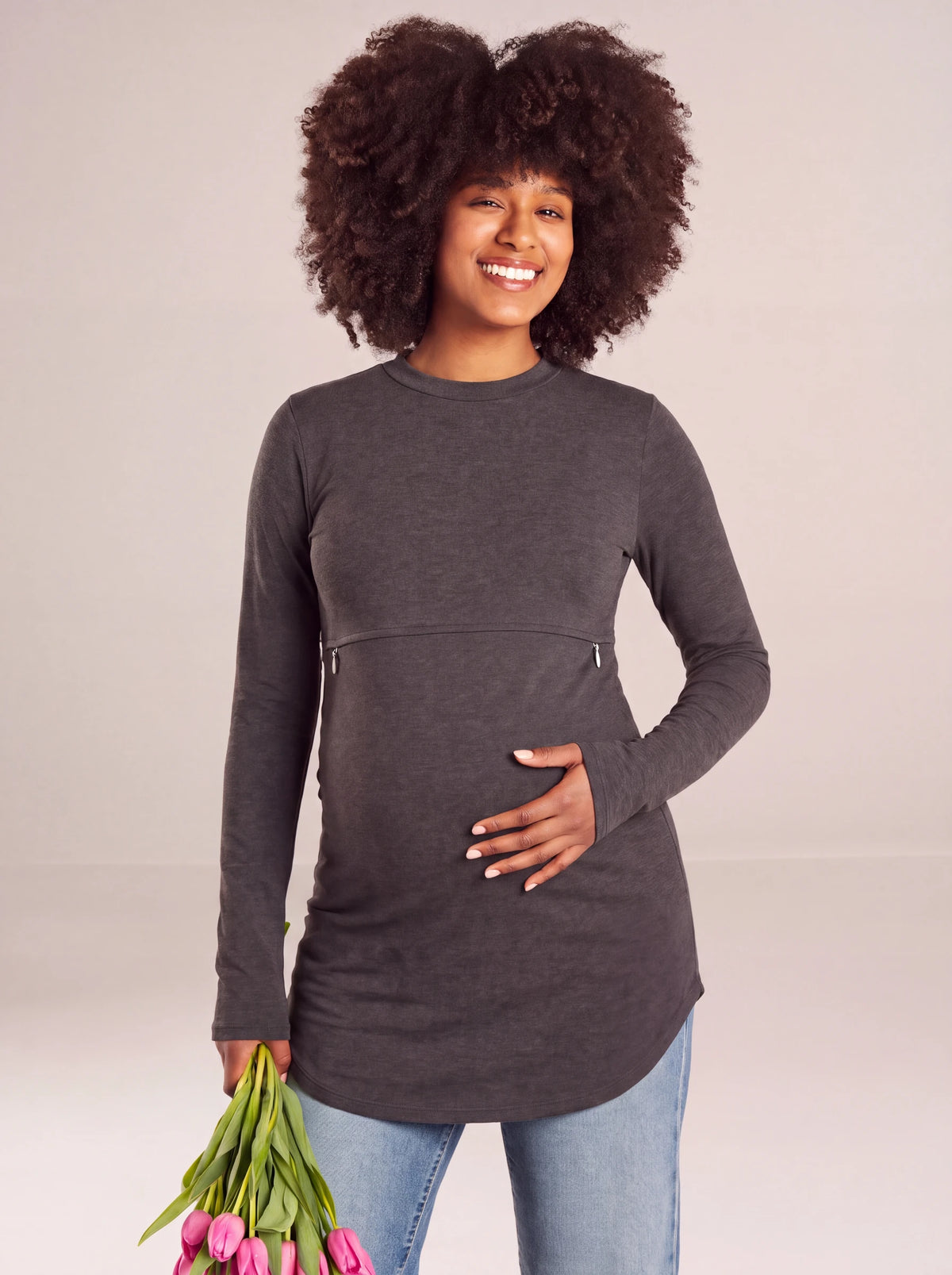 Pregnant woman holding tulips in the studio, dark gray nursing tee