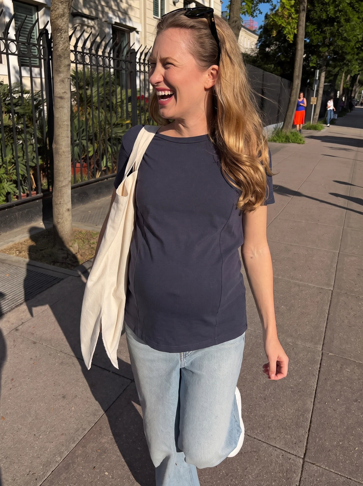 Pregnant mom walking in the city in navy maternity tee