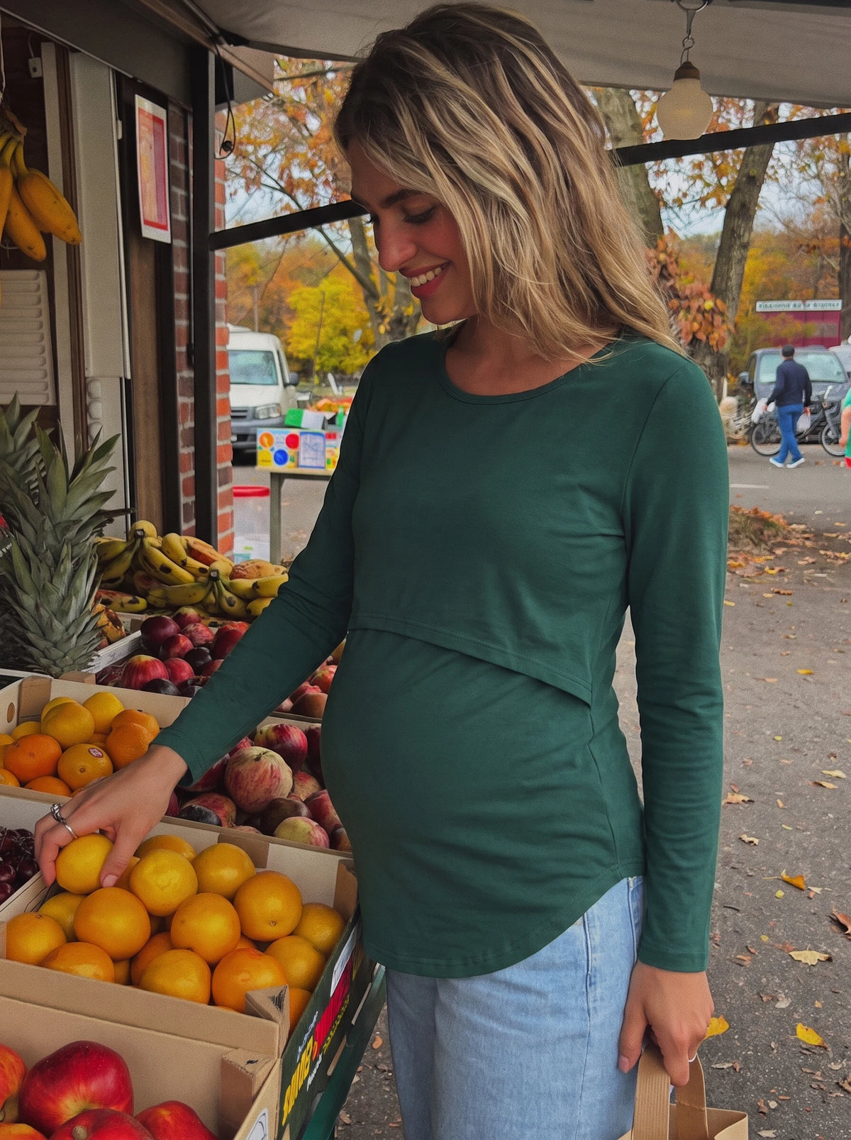 Pregnant woman at a market in a forest green nursing top