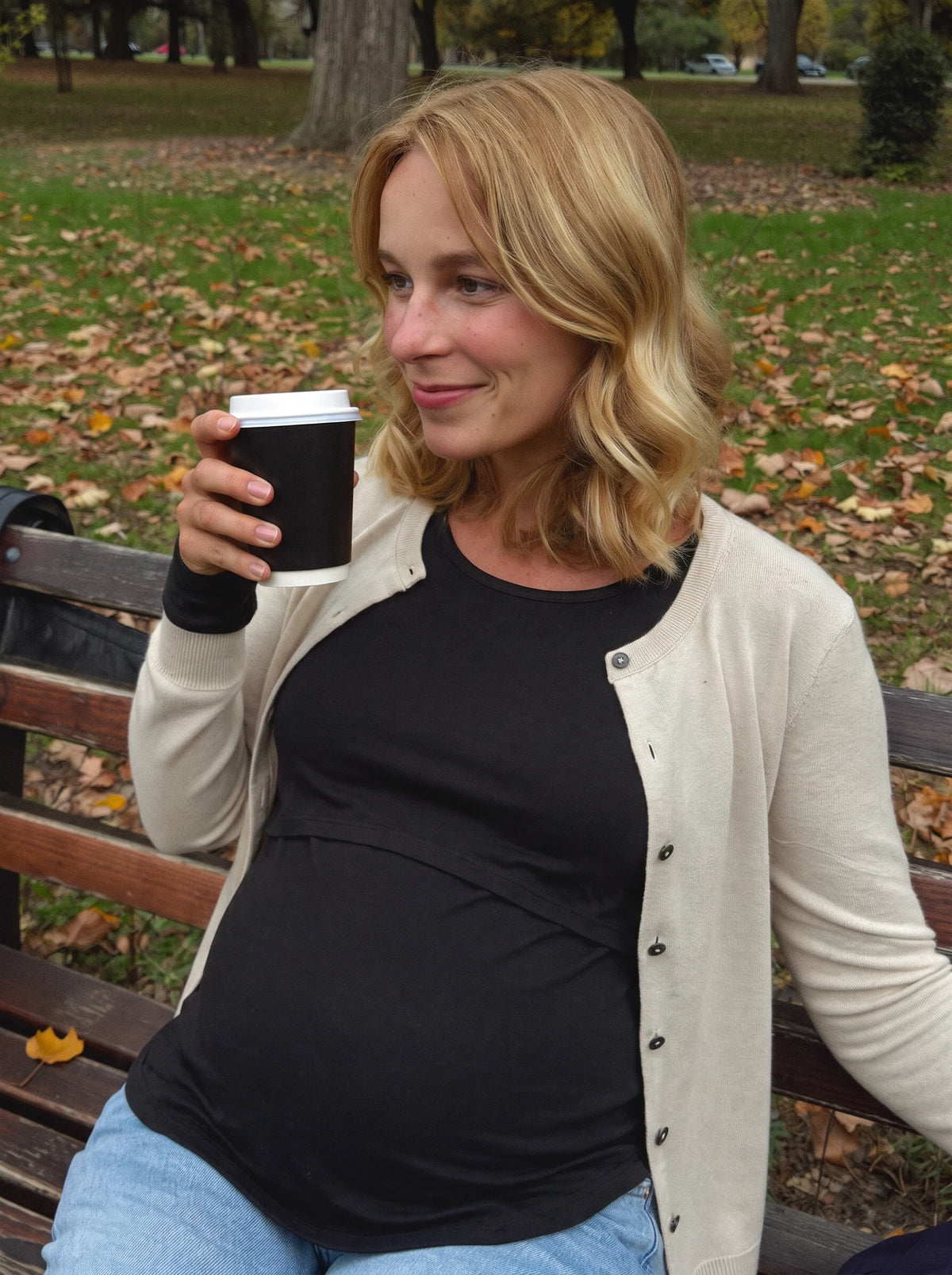 Black nursing top under a cardigan in the park