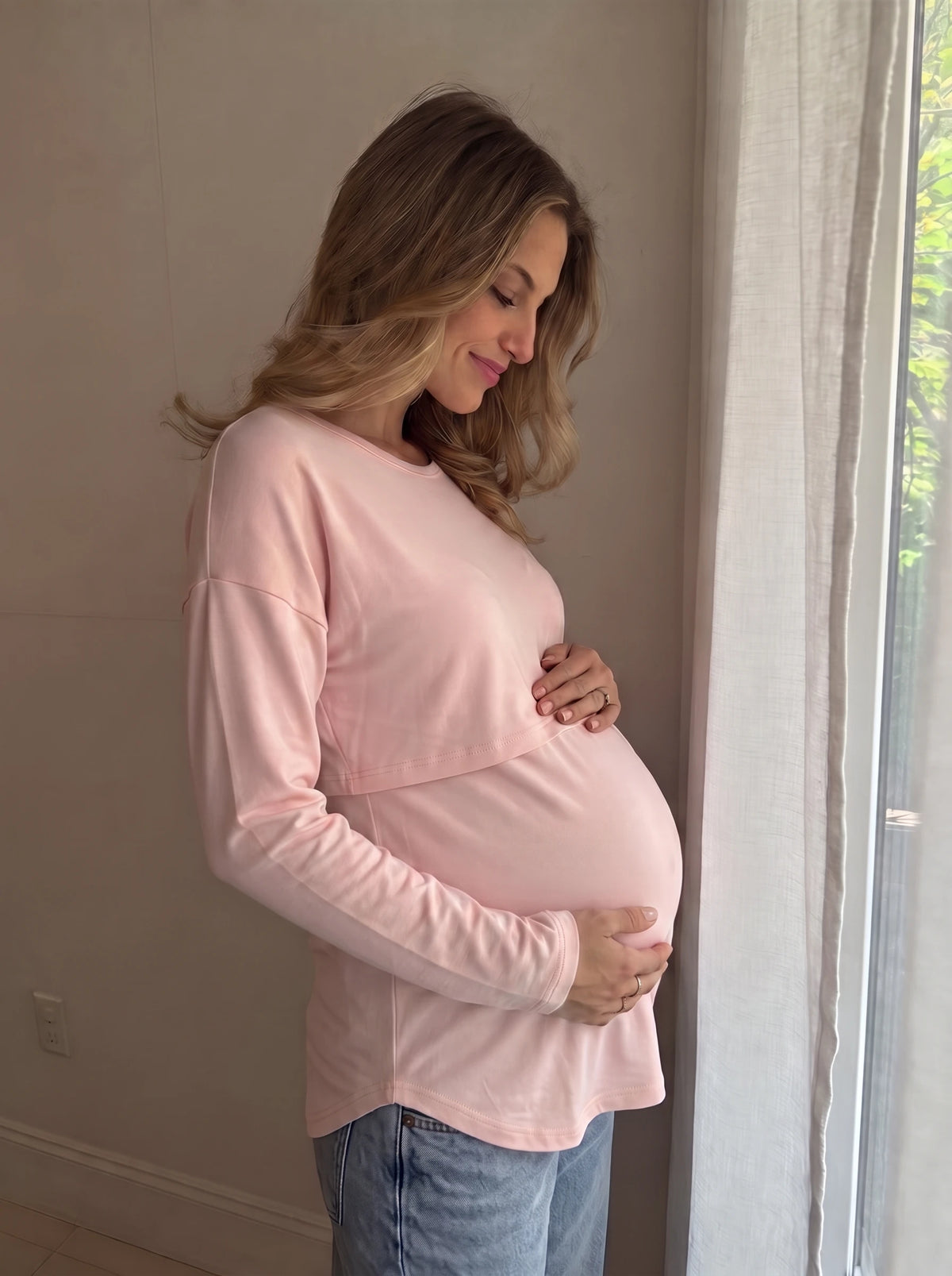 Blush pink nursing top draping softly over the bump, side view