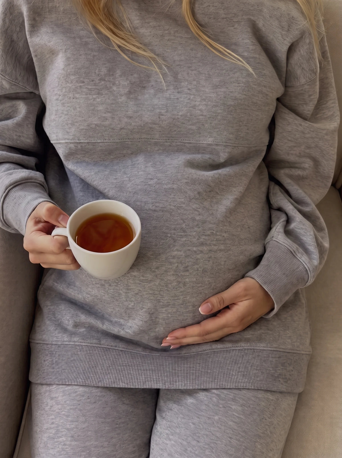 Close up of tea and soft cotton nursing sweatshirt over the bump