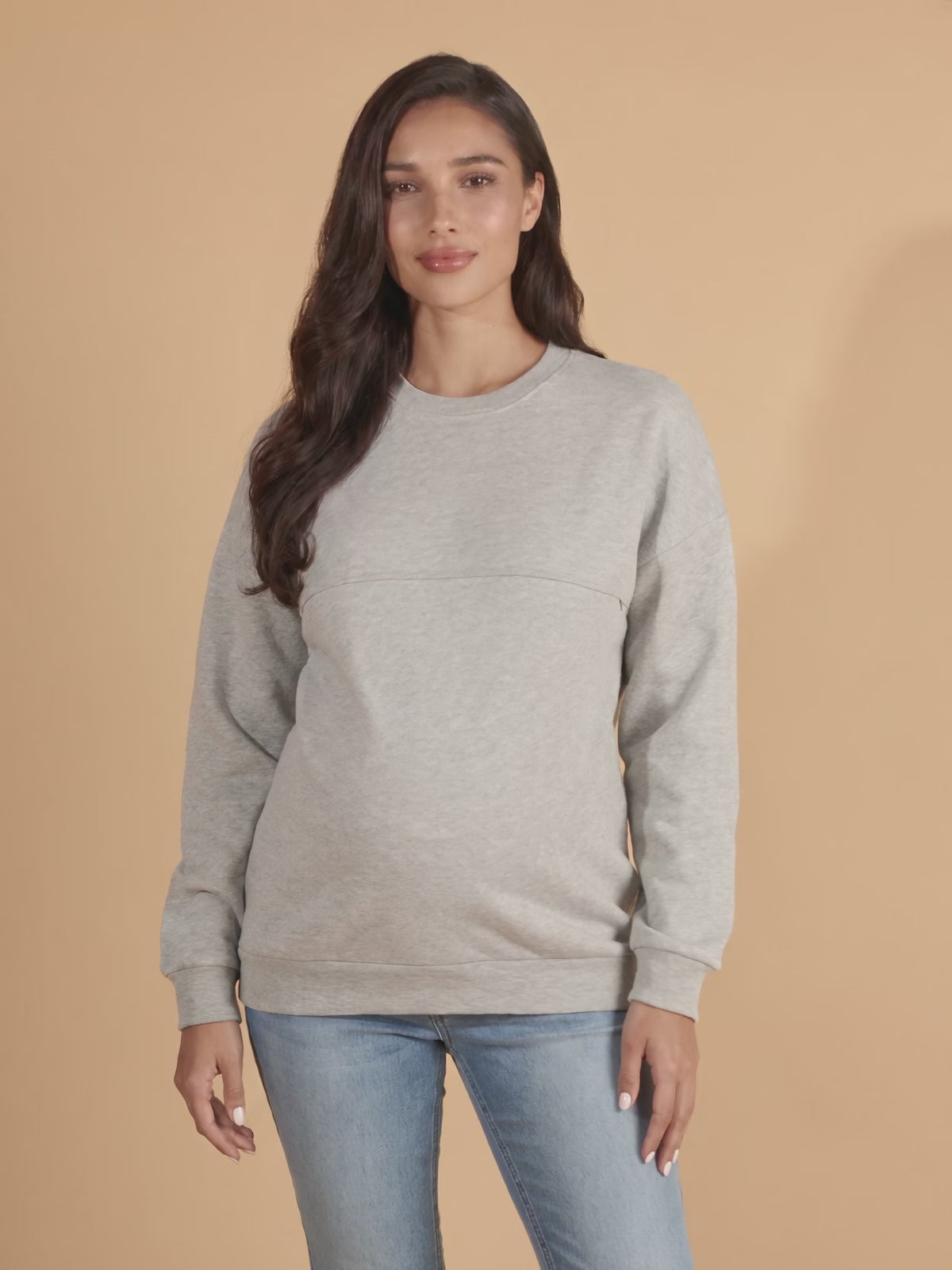 Pregnant mom in the gray hidden zip nursing sweatshirt turning to show the relaxed fit over the bump